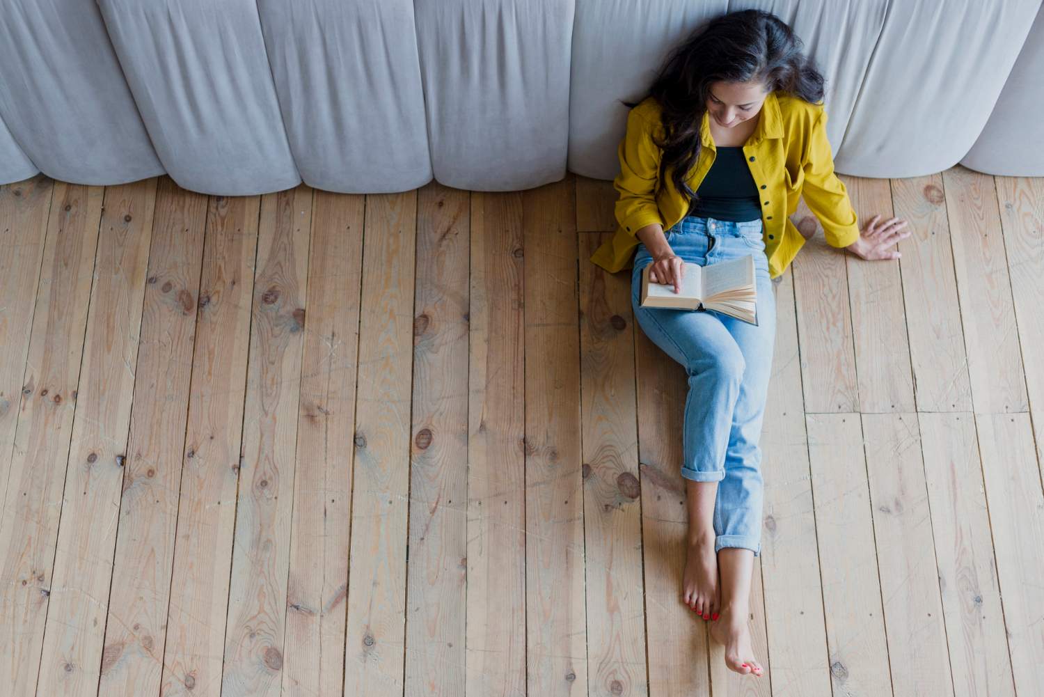 Profitez du confort exceptionnel d'un plancher chauffant installé par ADT génie climatique femme assis sur un plancher chaud